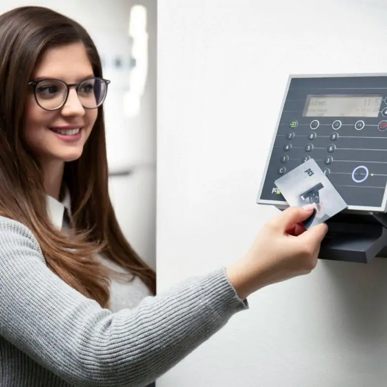A woman using a card-based access control system for secure entry.
